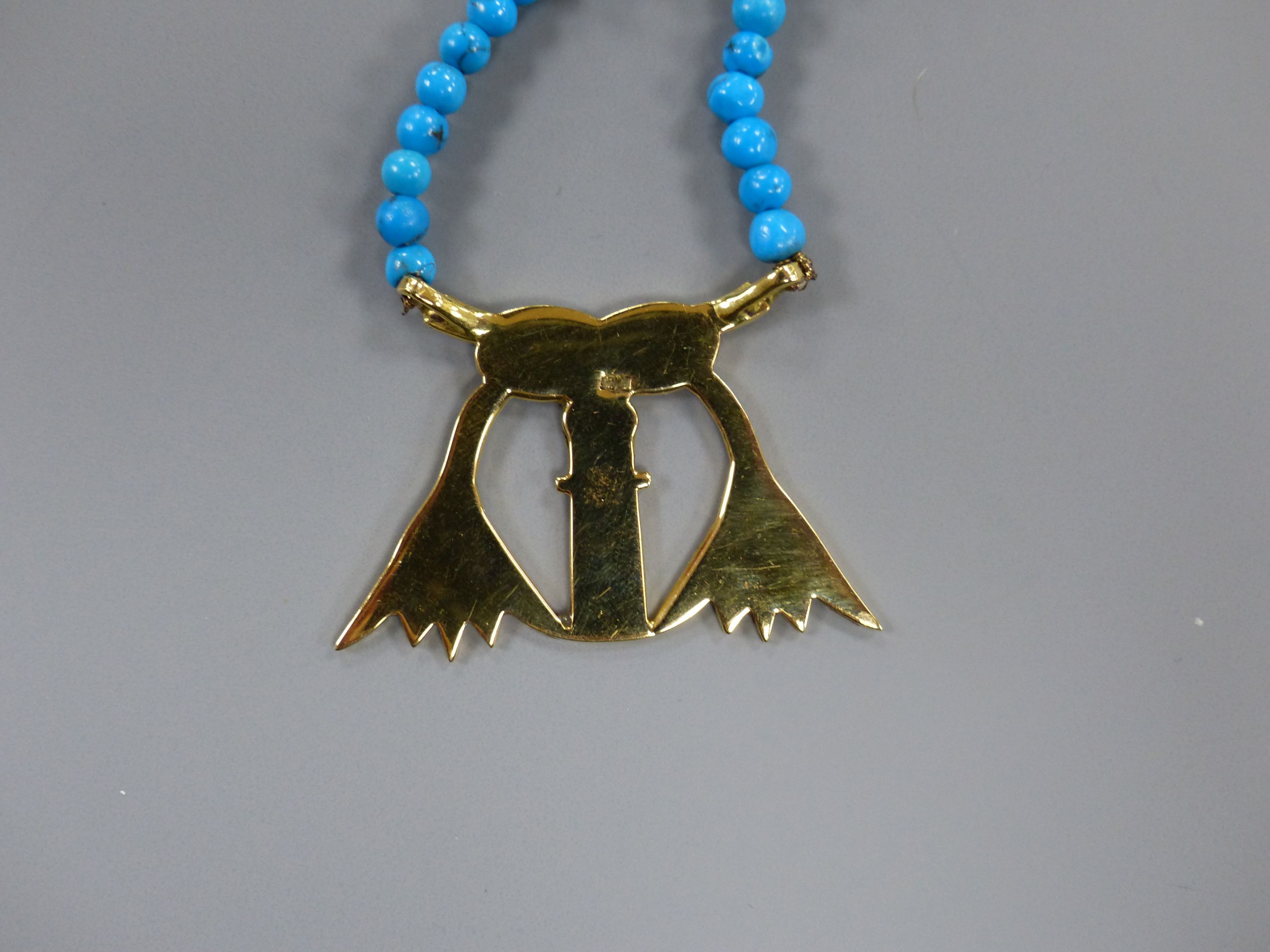 An Egyptian enamelled yellow metal pendant on turquoise and yellow metal bead necklace, the clasp marked 750, 54cm,